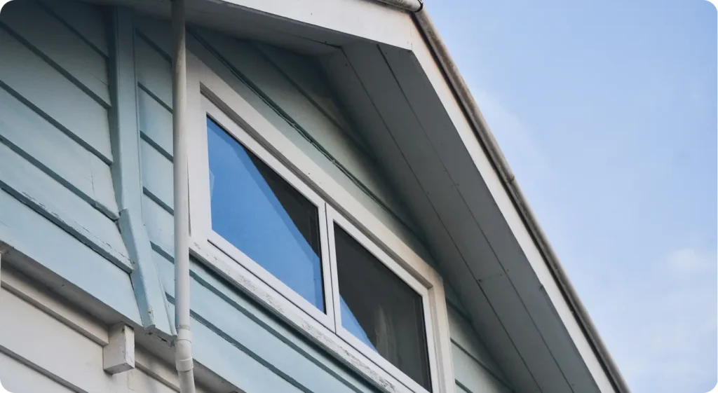 inspecting exterior of home including roofline, foundation, and gutters