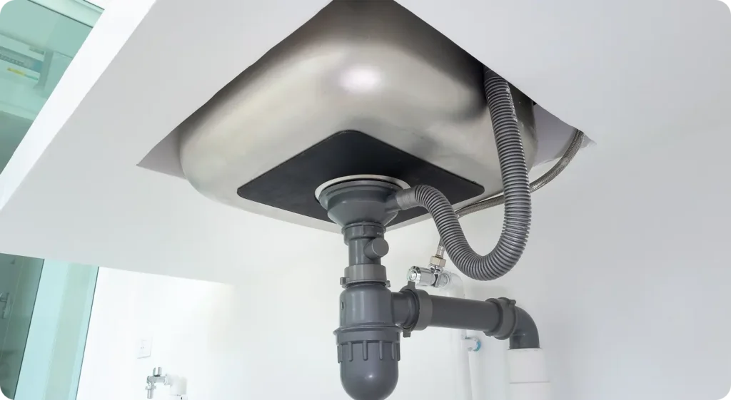 looking under sink for pest entry points around drain pipes